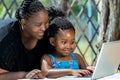 African mother and child looking at laptop outdoors. Royalty Free Stock Photo