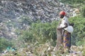 African mother collecting recyclables in trash. Mother with baby in sling collects recyclables from garbage