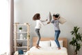 African mother and daughter enjoying pillow fight jumping on bed Royalty Free Stock Photo