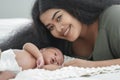 African mother and new born baby in diaper on a white bed. Young mom smile and looking at camera with her little infant boy sleepi Royalty Free Stock Photo