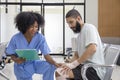 African nurse is examining tendinitis on knee injury from sport accident in Middle East patient for treatment and rehabilitation Royalty Free Stock Photo