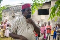 An African Older Man, The Mayor of His Village in Red Muslim Taqiyyah Hat and White Dress. Small Remote Village in Royalty Free Stock Photo
