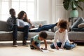 African parents relaxing on sofa while kids playing together dra Royalty Free Stock Photo