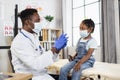 African pediatrician injecting vaccine to cute african girl