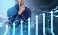 African pensive businessman and graph hologram with arrows, forex diagrams Royalty Free Stock Photo