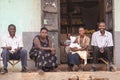 African family sitting with baby in front of the house, happy family with children in front of shop, smile engagingly