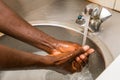 African person washing hands in basin to protect against spread of virus