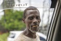 African poor man in a street by a passing car asks for money for food on the island of Zanzibar, Tanzania, East Africa, close up