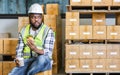 African professional male worker, holding cup coffee, burger, having lunch, taking break, work in storage, warehouse or factory Royalty Free Stock Photo