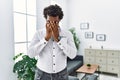 African psychologist man at consultation office with sad expression covering face with hands while crying Royalty Free Stock Photo