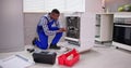 African Repairman Repairing Dishwasher Appliance Royalty Free Stock Photo