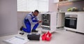 African repairman repairing dishwasher appliance Royalty Free Stock Photo