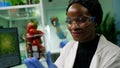 African researcher looking at glass with healthy strawberry Royalty Free Stock Photo