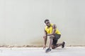 African runner in yellow sportswear stretching before doing morn Royalty Free Stock Photo