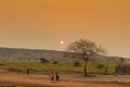African rural people returning from work, with sunset. Sumbe. An