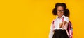 African Schoolgirl Gesturing Thumbs-Down In Dislike Over Yellow Background, Panorama