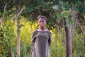 African schoolgirl in green school uniform against a forest background