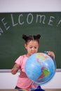 African schoolgirl looking globe with chalk background