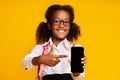 African Schoolgirl Showing Blank Phone Screen Over Yellow Background, Mockup Royalty Free Stock Photo