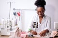 African seamstress working with fabric takes measures