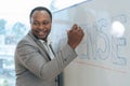 African senior male calculus professor is writing on whiteboard in the classroom Royalty Free Stock Photo