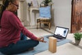 African senior woman doing online yoga lesson at home during lockdown isolation  - Focus on hand Royalty Free Stock Photo