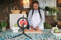 African senior woman streaming online vegetarian cooking virtual masterclass lesson outdoors at home - Focus on hands