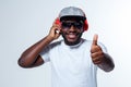 An african singer is showing thumb up while listening to music