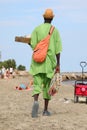 african street vendor walks on the beach  with green dress in summer Royalty Free Stock Photo