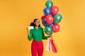 african teen girl with balloons and bags showing card, studio Royalty Free Stock Photo