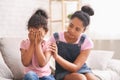 African teen girl embracing her crying baby sister Royalty Free Stock Photo