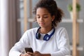 African teen girl with headphone search music in mobile app Royalty Free Stock Photo