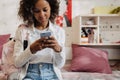 African teen girl with phone texting or using mobile apps Royalty Free Stock Photo