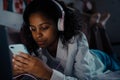 African teen girl using mobile apps at night Royalty Free Stock Photo