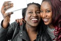 African teen girls taking self portrait with smartphone.