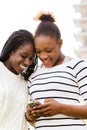 African teen girls texting on smart phone. Royalty Free Stock Photo