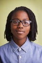 African teenager, glasses and portrait in studio for education, learning and knowledge on a green background. Face of Royalty Free Stock Photo