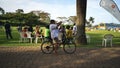 African teenager rides a bicycle in the park and taking a photo selfie on phone camera by the Victoria Lake in Kampala, Uganda
