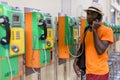 African tourist man talking on payphone and thinking Royalty Free Stock Photo