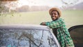 African traveler man is enjoying beautiful landscape during summer adventure in mountain at sunset. Travel car concept Royalty Free Stock Photo