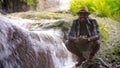 African traveler man sitting and relaxing freedom with waterfall.16:9 style