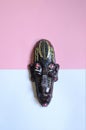 A African tribal face mask small show piece on white and pink background