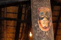African tribal mask of mans face hanging in bush camp