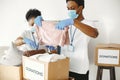 African volunteers in protective masks and gloves pack boxes