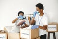 African volunteers in protective masks and gloves pack boxes