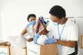 African volunteers in protective masks and gloves pack boxes