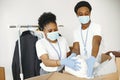 African volunteers in protective masks and gloves pack boxes