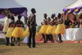 African wedding party in the park with beautiful girls dancing in traditional dresses with yellow skirts and the leading of the ce