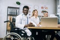 African doctor in wheelchair having discussion with partners Royalty Free Stock Photo