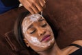 African Woman Applying Facial Mask In Spa Royalty Free Stock Photo